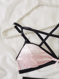 Detailansicht der rosa Samt-Lingerie mit schwarzen Kreuzgurten und kleiner Schleife