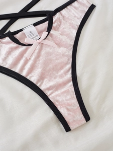 Detail einer rosa Samt-Unterwäsche mit schwarzem Rand, Schleife und Größenetikett