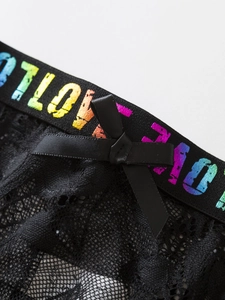 Macro view of black lace lingerie with a satin bow and rainbow LOVE lettered waistband