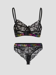 Close-up of black lace lingerie set with rainbow LOVE metallic waistband and heart patterns