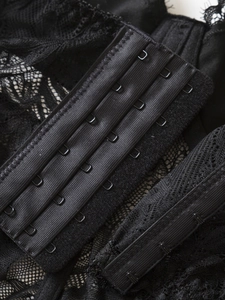 Detail of black lace corset back featuring four-row hook-and-eye closure for adjustment