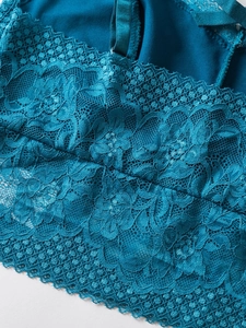 Close-up of deep lake blue lace camisole with floral embroidery and metal strap buckles