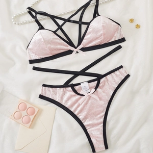 Dessous-Set aus rosa Samt mit Kontrastpaspel und Kreuzgurten auf weißem Stoff
