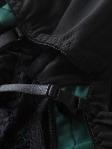 Close-up of black lace embroidery with adjustable straps and dark green lining detail