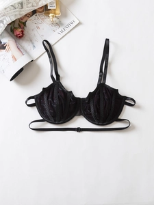 Detailed flat lay of black sheer lace underwire bra with delicate straps and rose decor