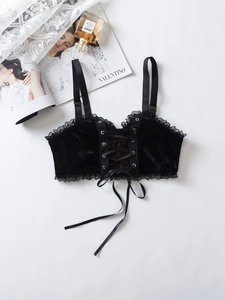 Détail d'un bustier en velours noir avec laçage frontal en ruban et fines bretelles
