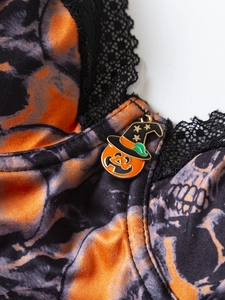 Dettaglio body Halloween con stampa teschi, pizzo nero e ciondolo a forma di zucca