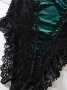 Detail of dark green velvet bodysuit with black lace trim and V-shaped stitching