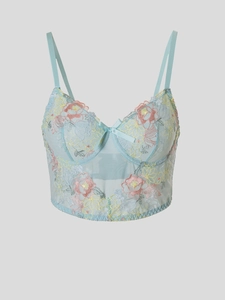 Dettaglio del corsetto in mesh azzurro con ricami floreali e fiocco sottile
