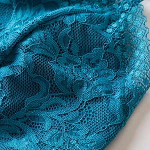 Front view of a teal floral lace camisole top with intricate mesh embroidery details
