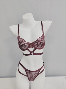 Dettaglio del set di lingerie in pizzo bordeaux con anello in metallo e spalline incrociate
