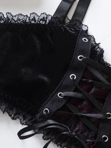 Détail de bustier en velours noir avec bordure en dentelle et laçage en ruban satin