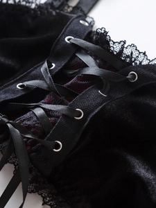 Détail d'un corset en velours noir avec ruban de laçage et bordure en dentelle cil fine