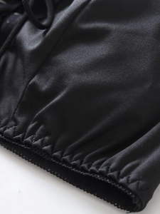 Macro shot of black erotic lingerie fabric with elastic ruching and decorative lace trim