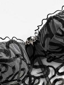 Close-up of gothic corset with snake pattern embroidery and silver bat metal buckle
