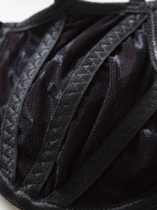 Macro shot of black mesh fabric with satin straps and detailed zigzag stitching finish