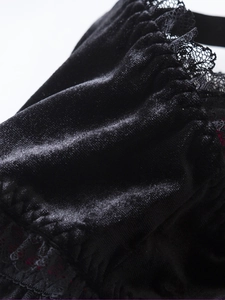 Détail du haut corset en velours noir montrant de la dentelle fine et un tissu plissé