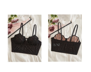 Détail d'un haut corset gothique noir avec structure baleinée et breloque croix