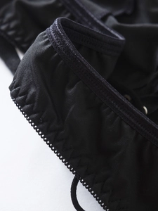 Macro detail of sexy black bikini set showing elastic textured fabric and reinforced stitching