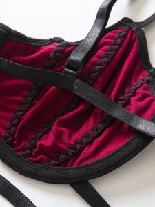 Detail of dark red lace bra with black contrast stitching and adjustable straps