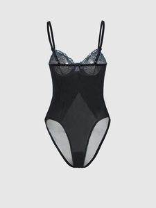 Détail de la dentelle florale noire et du tulle transparent sur un body sexy chic