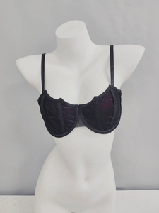 Macro shot of black lace detail and sheer mesh layering on an underwired bra
