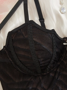 Détail de caraco gothique en dentelle noire avec broderie rayée et bretelles réglables