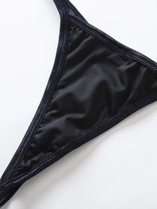 Detail of black satin bikini top with silver glitter elastic trim and shimmering edges