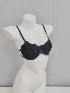 Detail of black sheer lace underwire bra showing vertical stitching and mesh texture