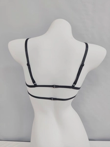 Detail of adjustable thin straps and back buckle design on black lace corset bra
