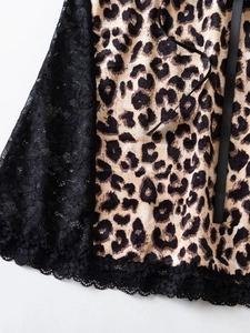 Detail von Leopardenmuster-Stoff mit schwarzer Wimpernspitze und Satin-Seitenbändern