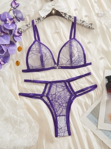 Close-up of purple lace bra set with silver bat buckle and ribbon details on silk