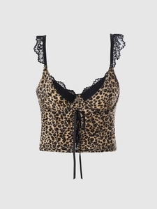 Detail of Y2K leopard corset top featuring black lace trim and metallic cross pendant