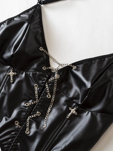 Dettaglio del corsetto Y2K in pelle nera con catene argentate e ciondoli a croce
