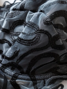 Vue macro du tissu en maille bleue avec broderie serpent noire détaillée et texture fine