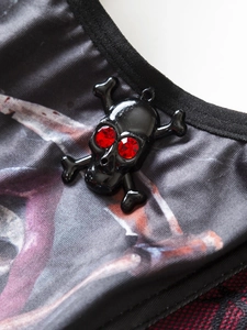 Macro detail of gothic skull pendant with red crystal eyes on dark printed fabric