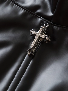 Dettaglio ravvicinato del corsetto Y2K in pelle PU nera con croce di strass e doppie cuciture