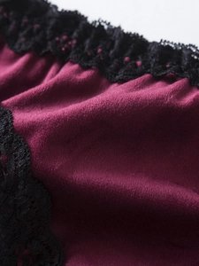Gros plan sur le tissu en velours bordeaux avec bordure en dentelle noire élégante