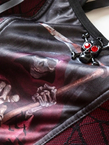 Detail of gothic grim reaper print with mesh trim and skull charm with red rhinestones