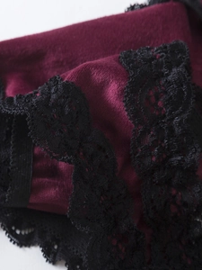 Détail du tissu en velours bordeaux avec dentelle florale noire délicate sur lingerie