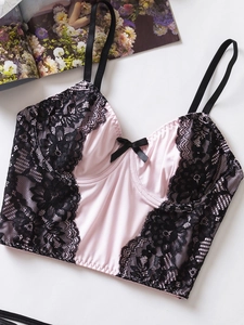 Détail de lingerie en satin rose avec bordure en dentelle noire et petit nœud devant