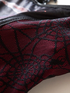 Macro close-up of breathable red mesh fabric with black spider web texture for Gothic top