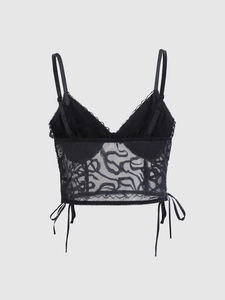 Détail du caraco en dentelle noire avec broderie en tulle transparent et nœuds