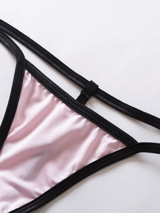 Détail de lingerie en satin rose avec dentelle noire et coutures de nœuds délicats