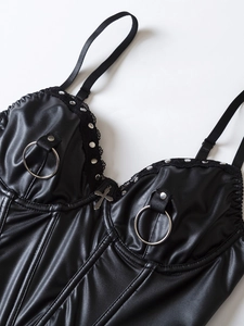Close-up of black PU leather corset with silver cross pendant, studs and lace trim detail