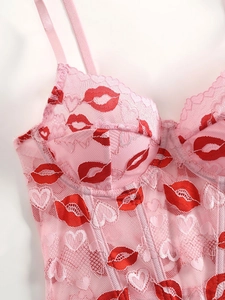 Detail of pink lace corset top with red lip prints, heart patterns and boning support