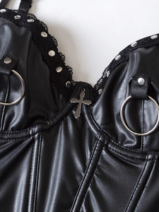 Detail of gothic PU leather corset featuring silver cross, studs, and lace trim detail