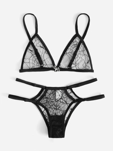 Detailed view of black spiderweb lace lingerie set with silver bat metal pendant