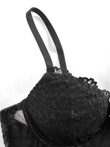 Close-up of black floral lace patterns and sheer mesh fabric on this corset camisole