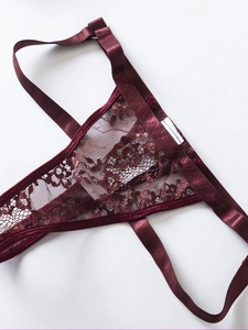 Dettaglio di lingerie in pizzo rosso vino con motivi floreali e rifiniture in raso lucido